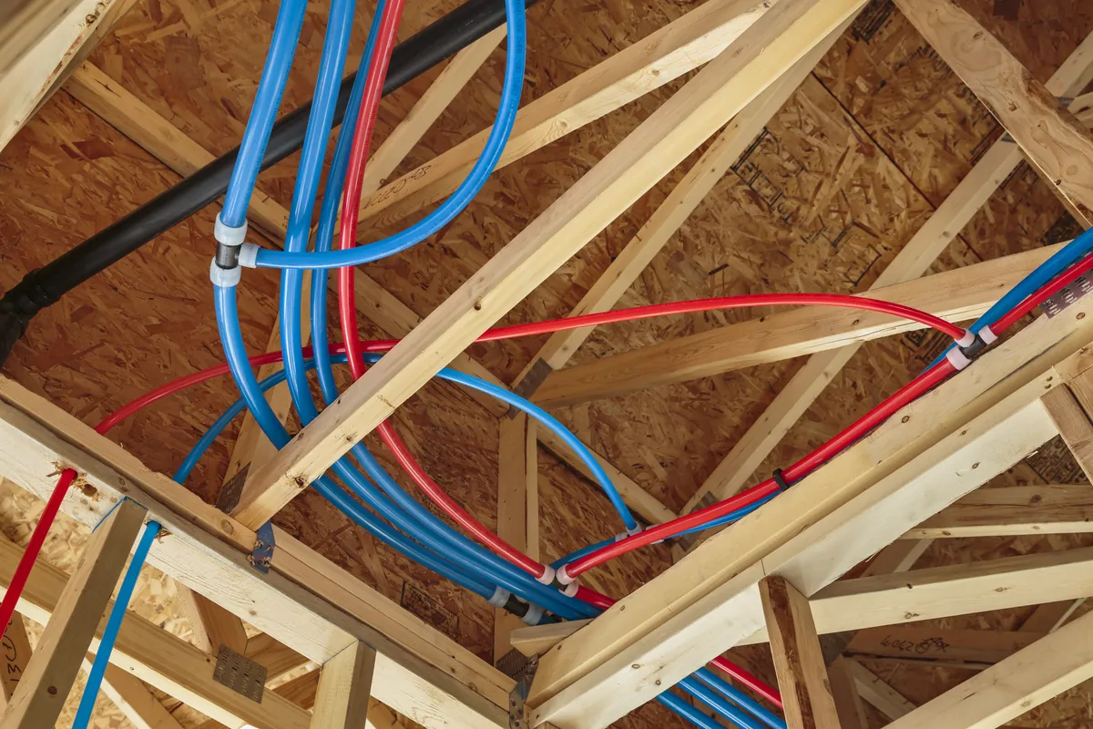 Red and blue PEX water lines run through attic trusses – Tankless Water Heater Installation for Laguna Niguel, CA homes